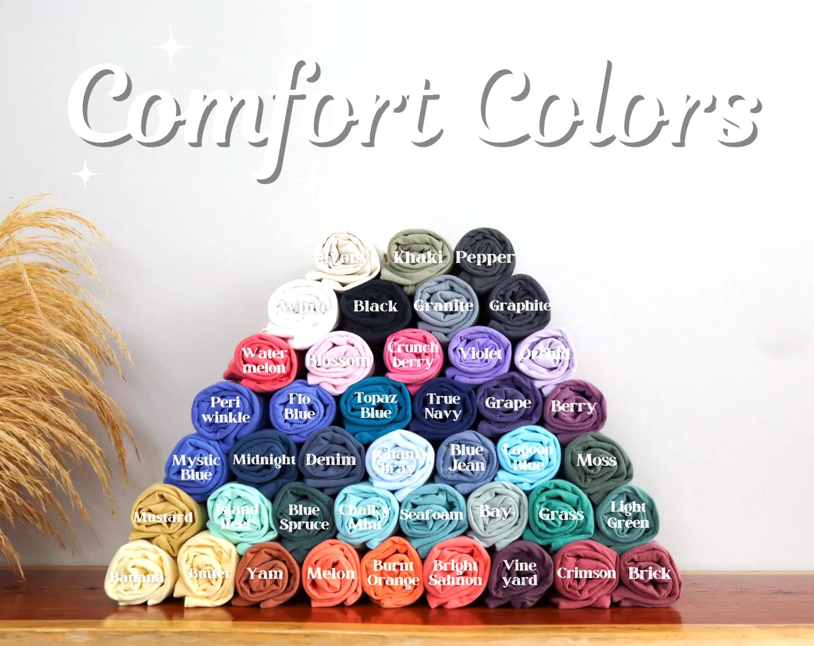 A pyramid-shaped arrangement of rolled-up fabric swatches in various colors, with the text "Comfort Colors" displayed above.